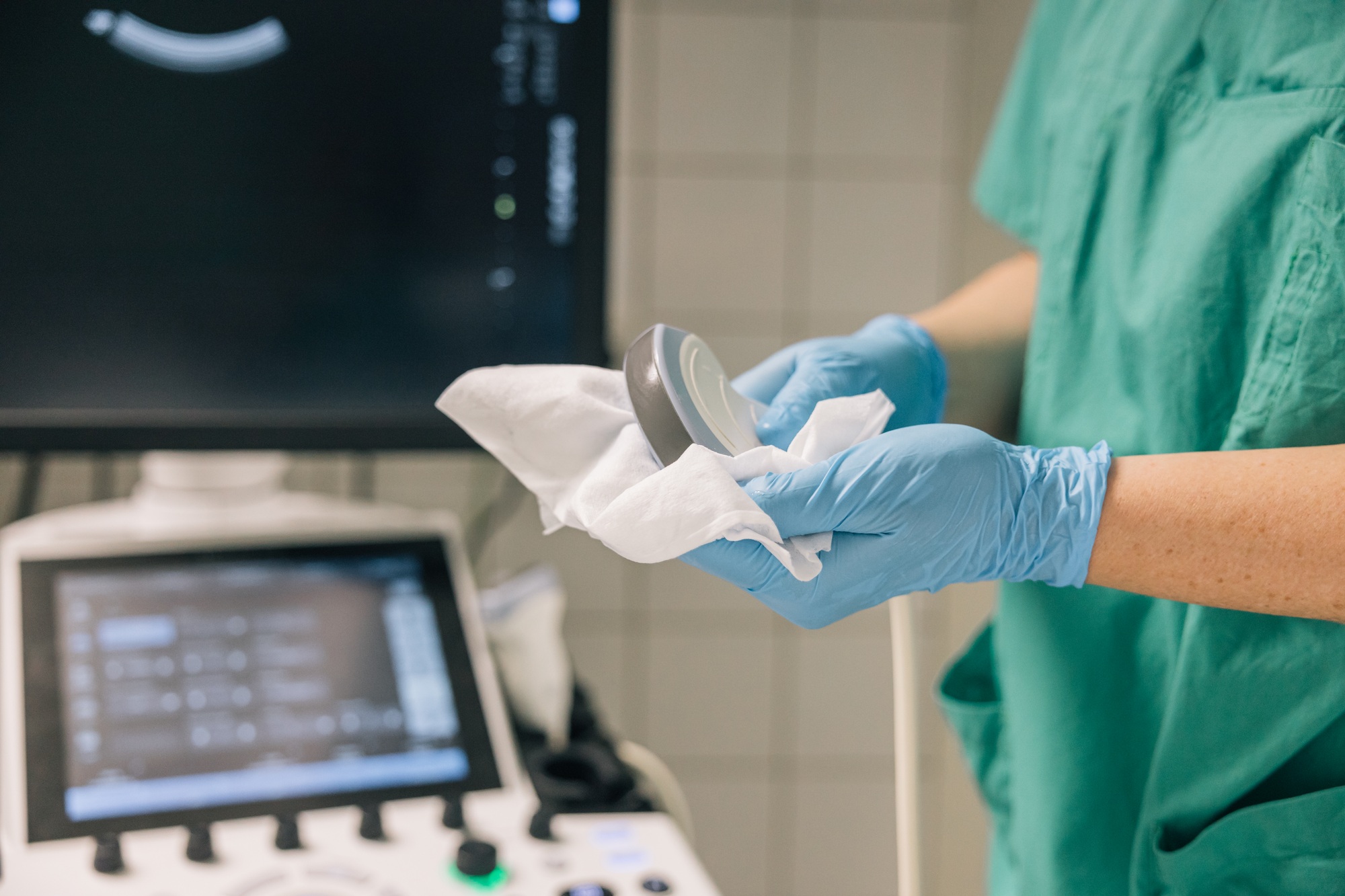 A healthcare professional cleaning the ultrasound head